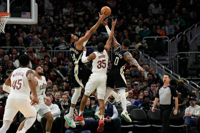 Jan 26, 2024; Milwaukee, Wisconsin, USA; Milwaukee Bucks forward Giannis Antetokounmpo (34), Cleveland Cavaliers forward Isaac Okoro (35) and Milwaukee Bucks guard Damian Lillard (0) reach for a rebound during the second quarter at Fiserv Forum.
